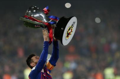 Barcelonas Argentinian forward Lionel Messi celebrates with the Liga trophy as Barcelona won their 26th league title after the Spanish League football match between Barcelona and Levante at the Camp Nou stadium in Barcelona on April 27, 2019. (Photo by PAU BARRENA / AFP)