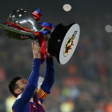 Barcelonas Argentinian forward Lionel Messi celebrates with the Liga trophy as Barcelona won their 26th league title after the Spanish League football match between Barcelona and Levante at the Camp Nou stadium in Barcelona on April 27, 2019. (Photo by PAU BARRENA / AFP)