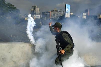  A member of the Bolivarian National Guard supporting Venezuelan opposition leader and self-proclaimed acting president Juan Guaido throws a tear gas canister during a confrontation with guards loyal to President Nicolas Maduro's government in front of La Carlota military base in Caracason April 30, 2019. - Guaido said on Tuesday that troops had joined his campaign to oust President Nicolas Maduro as the government vowed to put down what it called an attempted coup. (Photo by Yuri CORTEZ / AFP)Editoria: WARLocal: CaracasIndexador: YURI CORTEZSecao: crisisFonte: AFPFotógrafo: STF