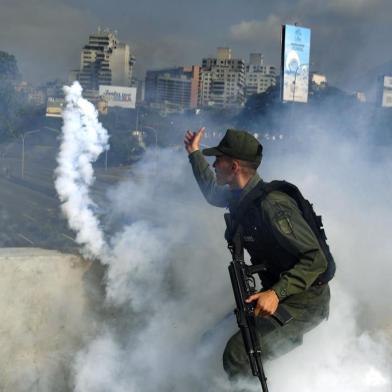  A member of the Bolivarian National Guard supporting Venezuelan opposition leader and self-proclaimed acting president Juan Guaido throws a tear gas canister during a confrontation with guards loyal to President Nicolas Maduro's government in front of La Carlota military base in Caracason April 30, 2019. - Guaido said on Tuesday that troops had joined his campaign to oust President Nicolas Maduro as the government vowed to put down what it called an attempted coup. (Photo by Yuri CORTEZ / AFP)Editoria: WARLocal: CaracasIndexador: YURI CORTEZSecao: crisisFonte: AFPFotógrafo: STF