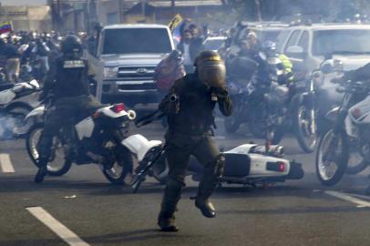  Members of the Bolivarian National Guard loyal to Venezuelan President Nicolas Maduro run under a cloud of tear gas after being repelled by guards supporting Venezuelan opposition leader and self-proclaimed acting president Juan Guaido upon arriving to disperse demonstrators, in front of La Carlota military base in Caracas on April 30, 2019. - Guaido said on Tuesday that troops had joined his campaign to oust President Nicolas Maduro as the government vowed to put down what it called an attempted coup. (Photo by Yuri CORTEZ / AFP)Editoria: WARLocal: CaracasIndexador: YURI CORTEZSecao: crisisFonte: AFPFotógrafo: STF