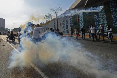  An opposition demonstrator clashes with soldiers loyal to Venezuelan President Nicolas Maduro after troops joined opposition leader Juan Guaido in his campaign to oust Maduro's government, in front of La Carlota military base in Caracas on April 30, 2019. - Venezuelan opposition leader and self-proclaimed acting president Juan Guaido said on Tuesday that troops had joined his campaign to oust President Nicolas Maduro as the government vowed to put down what it called an attempted coup. (Photo by Matias DELACROIX / AFP)Editoria: WARLocal: CaracasIndexador: MATIAS DELACROIXSecao: crisisFonte: AFPFotógrafo: STR