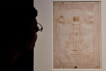 (FILES) In this file photo taken on May 13, 2015 a visitor looks at the Leonardos piece Vitruvian Man presented at the Palazzo Reale museum as part of the exhibition Leonardo Da Vinci on May 13, 2015 in Milan. - May 2019 marks the 500th anniversary of the death of Italian Renaissance master Leonardo da Vinci. (Photo by Giuseppe CACACE / AFP) / RESTRICTED TO EDITORIAL USE - MANDATORY MENTION OF THE ARTIST UPON PUBLICATION - TO ILLUSTRATE THE EVENT AS SPECIFIED IN THE CAPTION