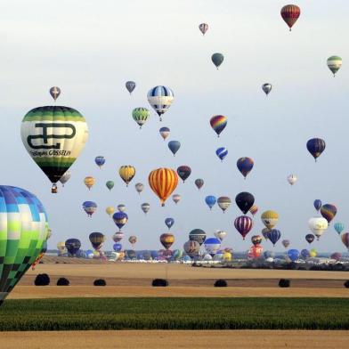 Hot air-balloons fly over a field of sunflowers in Chambley-Bussieres, eastern France on July 27, 2013 as part of the yearly event Lorraine Mondial Air  Ballons, an international air-balloon meeting. Around 363 to 373 air-balloons took part to the take-off in a try to set a worl record.AFP PHOTO /POOL ALEXANDRE MARCHI