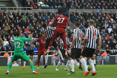 Liverpools Belgium striker Divock Origi (C) jumps to head home their third goal during the English Premier League football match between Newcastle United and Liverpool at St James Park in Newcastle-upon-Tyne, north east England on May 4, 2019. (Photo by Lindsey PARNABY / AFP) / RESTRICTED TO EDITORIAL USE. No use with unauthorized audio, video, data, fixture lists, club/league logos or live services. Online in-match use limited to 120 images. An additional 40 images may be used in extra time. No video emulation. Social media in-match use limited to 120 images. An additional 40 images may be used in extra time. No use in betting publications, games or single club/league/player publications. / 