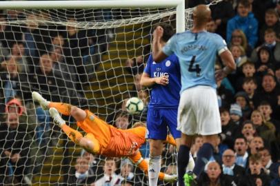 Manchester Citys Belgian defender Vincent Kompany (R) watches as his shot beats Leicester Citys Danish goalkeeper Kasper Schmeichel (L) to score the opening goal during the English Premier League football match between Manchester City and Leicester City at the Etihad Stadium in Manchester, north west England, on May 6, 2019. (Photo by Oli SCARFF / AFP) / RESTRICTED TO EDITORIAL USE. No use with unauthorized audio, video, data, fixture lists, club/league logos or live services. Online in-match use limited to 120 images. An additional 40 images may be used in extra time. No video emulation. Social media in-match use limited to 120 images. An additional 40 images may be used in extra time. No use in betting publications, games or single club/league/player publications. / 