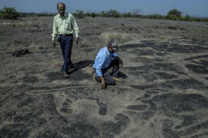 Sudhir Risbud, left, and Dhananjay Marathe, both engineers and dedicated naturalists, at one of the many ancient rock carvings they uncovered in Ratnagiri, India.**EMBARGO: No electronic distribution, Web posting or street sales before Tuesday 2:30 a.m. ET May 7, 2019. No exceptions for any reasons. EMBARGO set by source.** Sudhir Risbud, left, and Dhananjay Marathe, both engineers and dedicated naturalists, at one of the many ancient rock carvings they uncovered in Ratnagiri, India, April 15, 2019. The two amateur archaeologists have uncovered a collection of mysterious rock carvings on the Indian coastal plain south of Mumbai. (Atul Loke/The New York Times)Editoria: ALocal: RATNAGIRIIndexador: ATUL LOKEFonte: NYTNSFotógrafo: STR