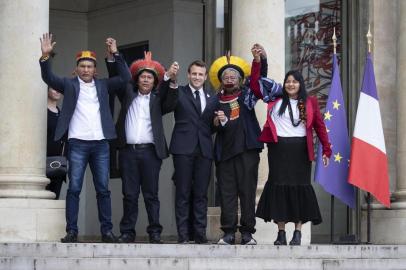 Brazils legendary indigenous chief Raoni Metuktire (2nd L) and three indigenous leaders from the Xingu reserve pose with French President Emmanuel Macron (C) after their meeting at the Elysee Palace on May 16, 2019 in Paris, part of the Brazilian leaders three-week tour across Europe where they will meet heads of state, celebrities and the Pope to highlight growing threats to the Amazon. - The elderly Kayapo chief, internationally recognisable through his traditional lip plate and feather headdress, will seek to raise one million euros (1,1 million USD) to better protect the Amazons Xingu reserve, home to many of Brazils tribal peoples, from loggers, farmers and fire. (Photo by Thomas SAMSON / AFP)