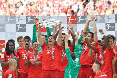 Bayern Munich players including Bayern Munichs Polish forward Robert Lewandowski celebrate with the trophy after the German First division Bundesliga football match FC Bayern Munich v Eintracht Frankfurt in Munich, southern Germany,  on May 18, 2019. (Photo by John MACDOUGALL / AFP) / DFL REGULATIONS PROHIBIT ANY USE OF PHOTOGRAPHS AS IMAGE SEQUENCES AND/OR QUASI-VIDEO