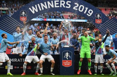 Manchester Citys Belgian captain Vincent Kompany (C) lifts the winners trophy as the players celebrate victory after the English FA Cup final football match between Manchester City and Watford at Wembley Stadium in London, on May 18, 2019. - Manchester City beat Watford 6-0 at Wembley to claim the FA Cup. (Photo by Daniel LEAL-OLIVAS / AFP) / NOT FOR MARKETING OR ADVERTISING USE / RESTRICTED TO EDITORIAL USE