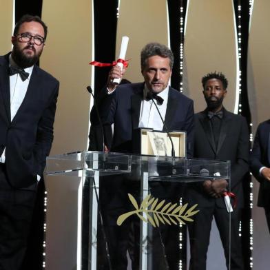 Brazilian film director Kleber Mendonca Filho (C) speaks on stage with Brazilian director Juliano Dornelles (L) after they shared the Jury Prize for their film Bacurau with French director Ladj Ly (2ndR) for his film Les Miserables on May 25, 2019 during the closing ceremony of the 72nd edition of the Cannes Film Festival in Cannes, southern France. (Photo by Valery HACHE / AFP)