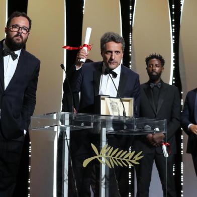 Brazilian film director Kleber Mendonca Filho (C) speaks on stage with Brazilian director Juliano Dornelles (L) after they shared the Jury Prize for their film Bacurau with French director Ladj Ly (2ndR) for his film Les Miserables on May 25, 2019 during the closing ceremony of the 72nd edition of the Cannes Film Festival in Cannes, southern France. (Photo by Valery HACHE / AFP)