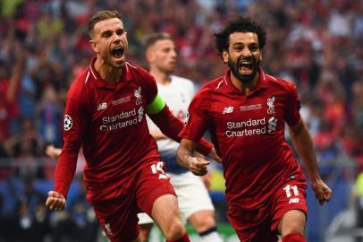 Liverpools Egyptian forward Mohamed Salah (R) celebrates with Liverpools English midfielder Jordan Henderson after scoring the opening goal during the UEFA Champions League final football match between Liverpool and Tottenham Hotspur at the Wanda Metropolitano Stadium in Madrid on June 1, 2019. (Photo by GABRIEL BOUYS / AFP)