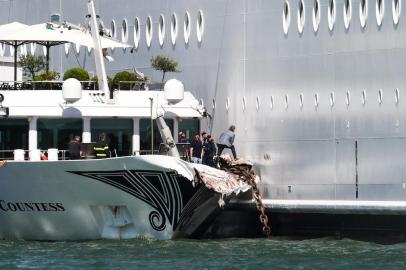 The damaged River Countess tourist boat is pictured after it was hit early on June 2, 2019 by the MSC Opera cruise ship (R) that lost control as it was coming in to dock in Venice, Italy. - Tourists on land could be seen running away as the MSC Opera scraped along the dockside, its engine blaring, before knocking into the River Countess tourist boat. (Photo by Andrea PATTARO / AFP)