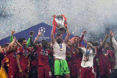 Liverpools Brazilian goalkeeper Alisson (C) raises the European Champion Clubs Cup as he celebrates with teammates winning the UEFA Champions League final football match between Liverpool and Tottenham Hotspur at the Wanda Metropolitano Stadium in Madrid on June 1, 2019. (Photo by Paul ELLIS / AFP)