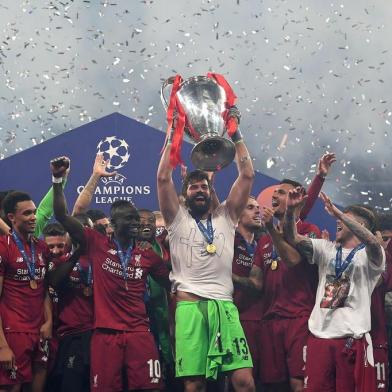 Liverpools Brazilian goalkeeper Alisson (C) raises the European Champion Clubs Cup as he celebrates with teammates winning the UEFA Champions League final football match between Liverpool and Tottenham Hotspur at the Wanda Metropolitano Stadium in Madrid on June 1, 2019. (Photo by Paul ELLIS / AFP)