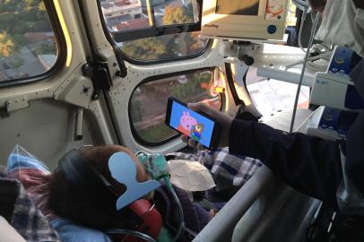 : Mauricio Lemos, do Samu (Serviço de Atendimento Móvel de Urgência) de Maringá (PR) distrai criança em transporte de helicóptero com vídeo da Peppa Pig