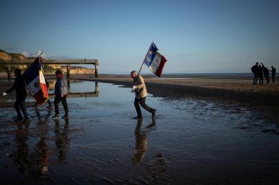  French veterans association members walk on Omaha beach, near Colleville-sur-Mer, Normandy, northwestern France, in the early morning of June 6, 2019 during the D-Day commemorations marking the 75th anniversary of the World War II Allied landings in Normandy. (Photo by FEDERICO SCOPPA / AFP)Editoria: SCILocal: Vierville-sur-MerIndexador: FEDERICO SCOPPASecao: human scienceFonte: AFPFotógrafo: STR