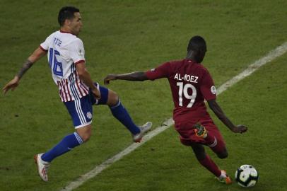 Qatars Almoez Ali (R) strikes the ball next to Paraguays Celso Ortiz to score during their Copa America football tournament group match at Maracana Stadium in Rio de Janeiro, Brazil, on June 16, 2019. (Photo by Mauro PIMENTEL / AFP)