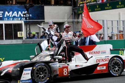 Toyota TS050 Hybrid LMP1 of Japaneses driver Kazuki Nakajima (C) Spains driver Fernando Alonso (R) and Switzerlands driver Sebastien Buemi celebrates after winning in the 87th edition of the 24 Hours Le Mans endurance race on June 16, 2019, at Le Mans northwestern France. (Photo by Fred TANNEAU / AFP)