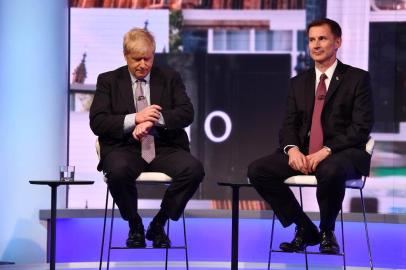 In a handout picture released by the British Broadcasting Corperation (BBC) on June 18, 2019 Conservative Party leadership contender Conservative MP Boris Johnson (L) checks his watch seated next to Britains Foreign Secretary Jeremy Hunt (R) during a BBC television leadership debate in London on June 18, 2019. - The UK leadership race narrowed to five in a second vote by MPs on June 18 with the remaining contenders taking part in a televised debate organised by the BBC. (Photo by JEFF OVERS / BBC / AFP) / RESTRICTED TO EDITORIAL USE - MANDATORY CREDIT  AFP PHOTO / JEFF OVERS-BBC  - NO MARKETING NO ADVERTISING CAMPAIGNS - DISTRIBUTED AS A SERVICE TO CLIENTS TO REPORT ON THE BBC PROGRAMME OR EVENT SPECIFIED IN THE CAPTION - NO ARCHIVE - NO USE AFTER  JULY 9, 2019 / 