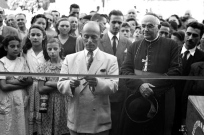 Feiras Livres, projeto inaugurado em 24 de dezembro de 1948, na esquina das ruas Dr. Montaury e Sinimbu. Na foto, prefeito Luciano Corsetti cortando a fita inaugural, juntamente com o bispo Dom Jose Barea.