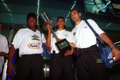 Foto dos jogadores Índio, Márcio e Picoli, da equipe do juventude com o troféu no aeroporto no Rio de Janeiro, após a conquista do título da copa do brasil. Botafogo 0x0 Juventude.#PÁGINA:60#EDIÇÃO: 2ª