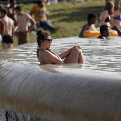 A woman bathe in the Trocadero Fountain near the Eiffel Tower in Paris during a heatwave on June 28, 2019. - The temperature in France on June 28 surpassed 45 degrees Celsius (113 degrees Fahrenheit) for the first time as Europe wilted in a major heatwave, state weather forecaster Meteo-France said. (Photo by Zakaria ABDELKAFI / AFP)