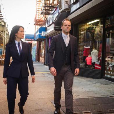 elementary , Sherlock Holmes (Jonny Lee Miller) e Lucy Liu (doutora Joan Watson)