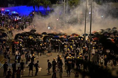 Police fire tear gas at protesters near the government headquarters in Hong Kong on July 2, 2019, on the 22nd anniversary of the citys handover from Britain to China. - Hundreds of protesters stormed Hong Kongs parliament late on July 1 as the territory marked its China handover anniversary, ransacking the building and daubing its walls with graffiti as the city plunged into unprecedented depths of political chaos. (Photo by Anthony WALLACE / AFP)