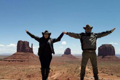 Seu olhar ¿ Estados Unidos Durante nossa viagem em uma Harley Davidson através da Rota 66, aproveitamos para conhecer o Monument Valley, retratado inúmeras vezes nos filmes dirigidos pela lenda de Hollywood John Ford. Na imagem, estamos eu e meu marido entre os East e West Mitten Buttes e o Merrick Butte, os monolitos mais famosos do local. Além deles, outro lugar a ser visitado é o monumento chamado as ¿quatro esquinas¿, que delimita as fronteiras entre Utah, Colorado, Novo México e Arizona, podendo-se estar nos quatro estados ao mesmo tempo! A arte dos Navajos, tribo nativa da região pode ser contemplada e adquirida no centro de visitas e também próxima aos monolitos, vendida diretamente pelos navajos. Um passeio imperdível em um país de tantas belezas naturais. Ana Paula Ott e Ricardo Ott, de Porto Alegre.Viagem realizada em maio de 2016.