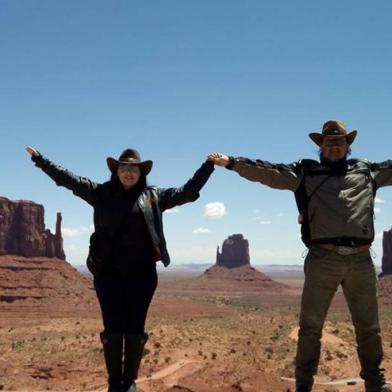 Seu olhar ¿ Estados Unidos Durante nossa viagem em uma Harley Davidson através da Rota 66, aproveitamos para conhecer o Monument Valley, retratado inúmeras vezes nos filmes dirigidos pela lenda de Hollywood John Ford. Na imagem, estamos eu e meu marido entre os East e West Mitten Buttes e o Merrick Butte, os monolitos mais famosos do local. Além deles, outro lugar a ser visitado é o monumento chamado as ¿quatro esquinas¿, que delimita as fronteiras entre Utah, Colorado, Novo México e Arizona, podendo-se estar nos quatro estados ao mesmo tempo! A arte dos Navajos, tribo nativa da região pode ser contemplada e adquirida no centro de visitas e também próxima aos monolitos, vendida diretamente pelos navajos. Um passeio imperdível em um país de tantas belezas naturais. Ana Paula Ott e Ricardo Ott, de Porto Alegre.Viagem realizada em maio de 2016.