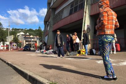 fila de moradores de rua em frente ao ginásio Gigantinho, do Inter, aguardando a abertura dos portões para passarem a noite de inverno do lado de dentro. frio