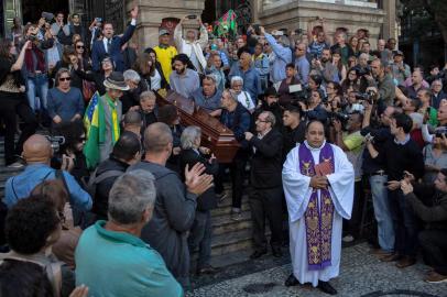 Relatives, friends and fans of late Brazilian musician Joao Gilberto surround his coffin as it is carried outside Rio de Janeiro Municipal Theater during his funeral in Rio de Janeiro, Brazil, on July 08, 2019. - Joao Gilberto, the legendary Brazilian musician and songwriter who was a pioneer of the lilting, melodious music known as bossa nova, has died at 88. (Photo by IAN CHEIBUB / AFP)