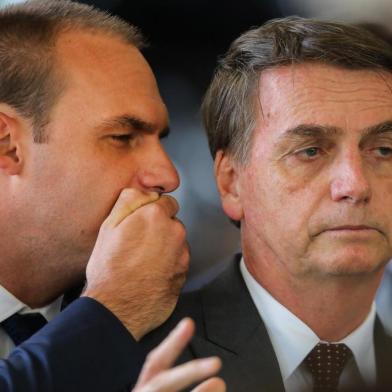 President-elect Jair Bolsonaro (R) listens to his son Eduardo Bolsonaro (L) at the headquarters of the transitional government in Brasilia, on November 14, 2018. - Bolsonaro did the eighth ministerial appointment since winning the presidential election at the end of last month. (Photo by Sergio LIMA / AFP)