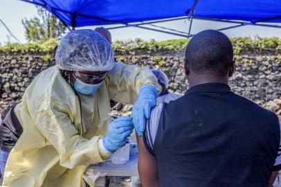 A man receives a vaccine against Ebola from a nurse outside the Afia Himbi Health Center on July 15, 2019 in Goma. - Authorities in Democratic Republic of Congo have appealed for calm after a preacher fell ill with Ebola in the eastern city of Goma, the first recorded case of the disease in the regions urban hub in a nearly year-old epidemic. (Photo by Pamela TULIZO / AFP)