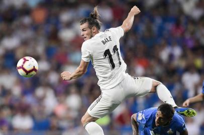 Real Madrids Welsh forward Gareth Bale (L) challenges Getafes Uruguayan defender Damian Suarez during the Spanish League football match between Real Madrid and Getafe at the Santiago Bernabeu stadium in Madrid on August 19, 2018. / AFP PHOTO / JAVIER SORIANO