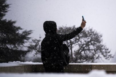  A person poses for a selfie under the snow on the Place du Trocadero in front the Eiffel Tower in Paris on February 5, 2018. / AFP PHOTO / Lionel BONAVENTUREEditoria: LIFLocal: ParisIndexador: LIONEL BONAVENTURESecao: tourismFonte: AFPFotógrafo: STF