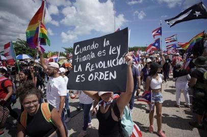 A woman displays a placard reading When the tyranny is law, the revolution is order as people take to the Las Americas Highway in San Juan, Puerto Rico, July 22, 2019 on day 9th of continuous protests demanding the resignation of Governor Ricardo Rosselló. - Protests erupted last week after the leak of hundreds of pages of text chats on the encrypted messaging app Telegram in which Rossello and 11 other male administration members criticize officials, politicians and journalists. In one exchange, chief financial officer Christian Sobrino makes homophobic references to Latin superstar Ricky Martin. In another, a mocking comment is made about bodies piled up in the morgue after Hurricane Maria, which left nearly 3,000 dead. (Photo by Eric Rojas / AFP)