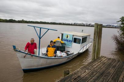  PORTO ALEGRE, RS, BRASIL. 27.07.2019. Entrega de alimentos e roupas recolhidas durante a Campanha do Agasalho pelo Sava Clube Náutico. Donativos são levados de veleiro ao pároco, o padre Rudimar na Ilha da Pintada.   (FOTO ANDRÉA GRAIZ/AGÊNCIA RBS).Indexador: Andrea Graiz