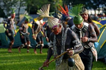 Riot police stand guard near indigenous people camping outside the National Congress building to protest in Brasilia, Brazil, on April 24, 2019. - Approximately 2,000 indigenous people from different tribes are taking part in protests  during the Indigenous National Mobilization (MNI) week, which seeks to tackle territorial rights' negotiations with the government. (Photo by CARL DE SOUZA / AFP). Acampamento da Terra Livre, que reúne indígenas em Brasília.