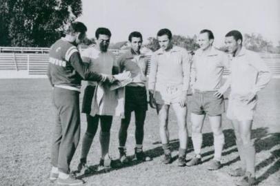 Foto histórica de Garrincha no estádio do Novo Hamburgo. O craque das pernas tortas aparece ao lado do técnico Crespo e dos jogadores Dirceu, Helenílson, Xameguinha e Sarão, durante um treino do time do Novo Hamburgo, no estádio Santa Rosa. Garrincha em fim de carreira. FD. Data Evento: 00/00/1969#PÁGINA:77#EDIÇÃO: 2ª Fonte: Arquivo Pessoal Fotógrafo: Alceu Feijó