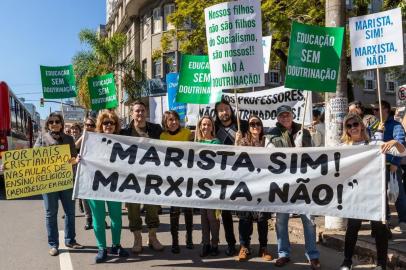 O protesto realizado por pais e apoiadores do grupo Escola sem Doutrinação em frente ao Colégio Marista Rosário, no bairro Independência, em Porto Alegre, nesta segunda-feira (5), foi motivado pelo que os manifestantes definem como "a gota d'água": uma briga entre dois adolescentes do 2º Ano do Ensino Médio no último dia de aula antes do recesso, no dia 23, que viralizou pelo WhatsApp. No vídeo de 33 segundos, que, bem como os nomes dos adolescentes, não será divulgado para preservá-los, um aluno e uma aluna se agridem com socos dentro da sala de aula. A escola confirma que as matrículas dos alunos foram canceladas e que o professor foi afastado _ sem esclarecer o motivo da demissão. 