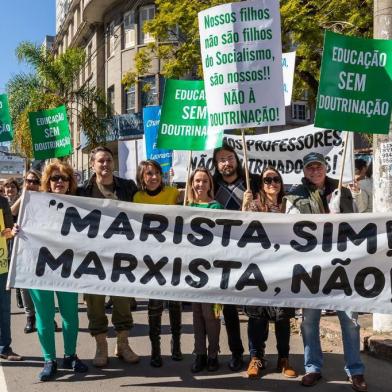 O protesto realizado por pais e apoiadores do grupo Escola sem Doutrinação em frente ao Colégio Marista Rosário, no bairro Independência, em Porto Alegre, nesta segunda-feira (5), foi motivado pelo que os manifestantes definem como a gota dágua: uma briga entre dois adolescentes do 2º Ano do Ensino Médio no último dia de aula antes do recesso, no dia 23, que viralizou pelo WhatsApp. No vídeo de 33 segundos, que, bem como os nomes dos adolescentes, não será divulgado para preservá-los, um aluno e uma aluna se agridem com socos dentro da sala de aula. A escola confirma que as matrículas dos alunos foram canceladas e que o professor foi afastado _ sem esclarecer o motivo da demissão. 