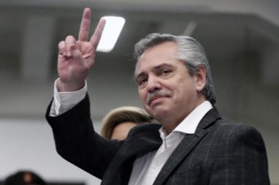 Presidential hopeful for the Frente de Todos (Front for All) party Alberto Fernandez flashes the V sign before voting during primary elections in Buenos Aires on August 11, 2019. - Primary elections in Argentina take place Sunday, ahead of the October vote. (Photo by ALEJANDRO PAGNI / AFP)