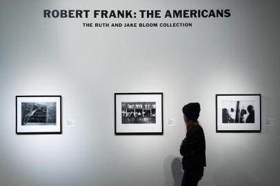 (FILES) In this file photo taken on December 17, a person looks at rare Robert Frank photographs from his book - Robert Frank, a pioneering documentary photographer whose raw style placed him among the 20th centurys greats, has died, according to The New York Times on September 10, 2019. He was 94 years old. The Swiss-born photographer rose to fame with the publication of his landmark 1958 book The Americans, an unflinching look at US society that proved hugely influential. (Photo by Bryan Thomas / GETTY IMAGES NORTH AMERICA / AFP) / RESTRICTED TO EDITORIAL USE - MANDATORY MENTION OF THE ARTIST UPON PUBLICATION - TO ILLUSTRATE THE EVENT AS SPECIFIED IN THE CAPTION