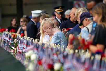 People leave flowers and flags during the September 11 Commemoration Ceremony at the 9/11 Memorial at the World Trade Center on September 11, 2019,in New York. (Photo by Don Emmert / AFP)