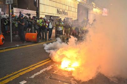 People react after police fired tear gas to clear pro-democracy protesters in the Causeway Bay district in Hong Kong on September 15, 2019. - Hong Kong riot police fired tear gas and water cannons on September 15 at hardcore pro-democracy protesters hurling rocks and petrol bombs, in a return to the political chaos plaguing the city. (Photo by Anthony WALLACE / AFP)