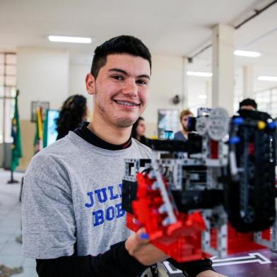  PORTO ALEGRE, RS, BRASIL, 18/09/2019: Leonardo Nunes, 20 anos, morador da Vila Mapa, conheceu a robótica na escola municipal e a levou para o Colégio Estadual Júlio de Castilhos, onde cursou o ensino médio. Hoje, ele é o instrutor dos estudantes e trabalha com robótica. Criou quatro equipes vencedoras na escola. A principal delas é a Julianos Robots, que conquistou na etapa regional da Olimpíada Brasileira de Robótica o título de escola pública. Fotos com os outros integrantes da equipe:Nicoly MarquesRodrigo da SilvaNathan SolanoRafael Rodrigues (cabeludo)Laira Alves (Foto: Omar Freitas / Agência RBS)Indexador: NGS