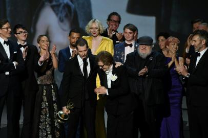 Writer-producers D.B. Weiss (C-L),and Bernadette Caulfield (C-R) and the cast of Game of Thrones accept the award Outstanding Drama series  onstage during the 70th Emmy Awards at the Microsoft Theatre in Los Angeles, California on September 17, 2018. / AFP PHOTO / Robyn Beck